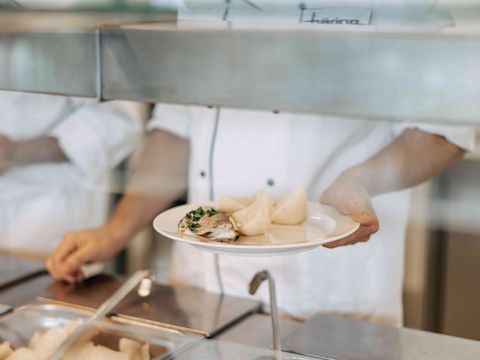 Person hält Teller mit Essen im Häring-Betriebsrestaurant