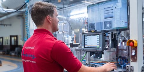 Häring-Auszubildender vor PC in der Produktion