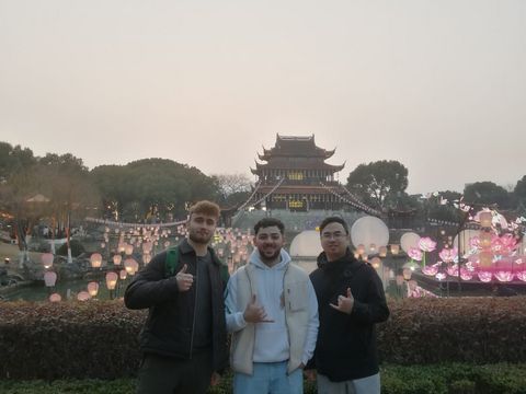 Drei Männer vor einem chinesischen Turm mit Laternen