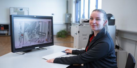 junge Auszubildende sitzt im Büro am PC vor einem CAD-Programm