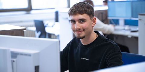 Häring-Auszubildender sitzt in der IT vor dem PC